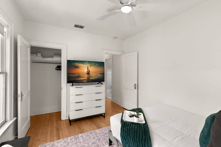 غرفة نوم بسرير كبير مع تلفزيون ذكي