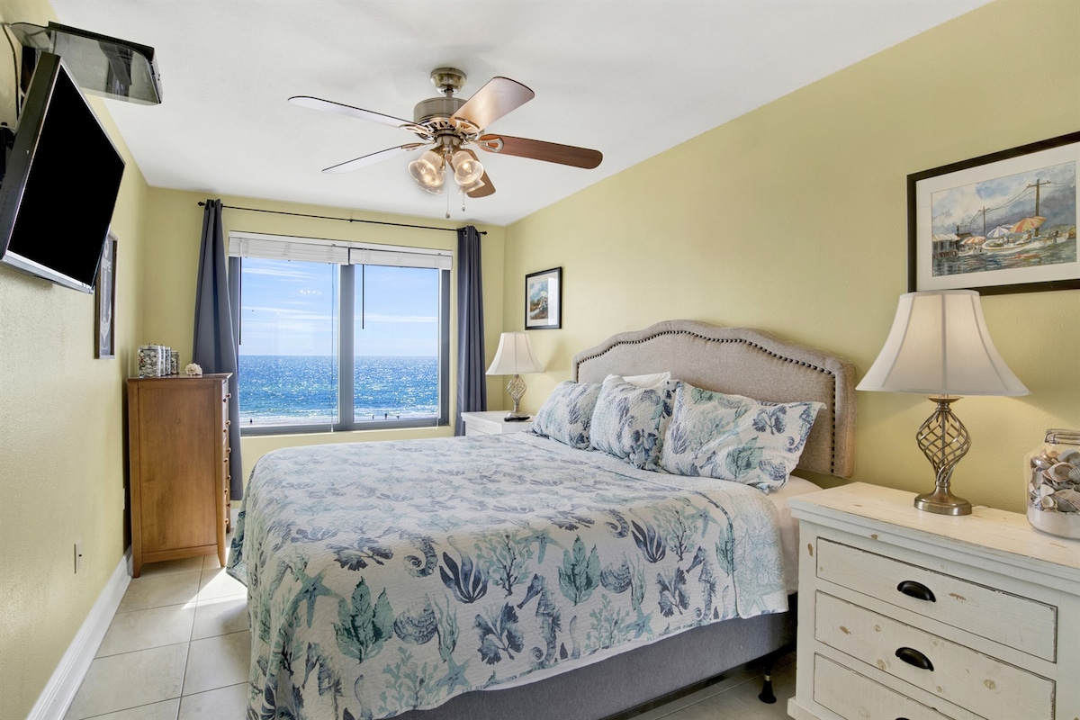 Puedes disfrutar de la INCREÍBLE vista desde el dormitorio principal que ofrece una cama tamaño king, ventilador de techo, cómoda, 2 mesitas de noche, TV inteligente montada en la pared y un armario doble.