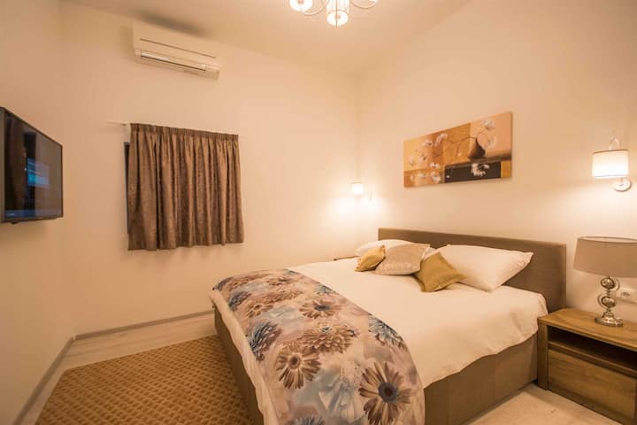 Напълно климатизирана спалня, декорирана с елегантни произведения на изкуството, с телевизор с плосък екран, оазис на почивка и релаксация