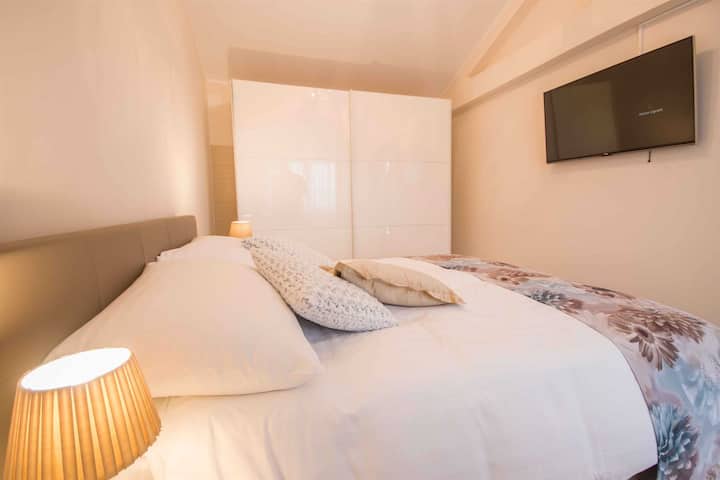 Телевизорът с плосък екран, монтиран на стената, гарантира, че дори и най - неспокойните нощни птици ще имат какво да гледат в тази спалня, докато бавно се носят в нежен сън на невероятно удобното легло