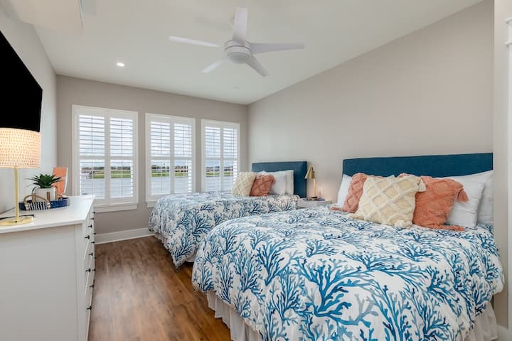 ห้องนอนแรกชั้นล่างมี 2 ควีนส์วิวอ่าวเล็กๆและอ่างอาบน้ำเต็มรูปแบบส่วนตัว