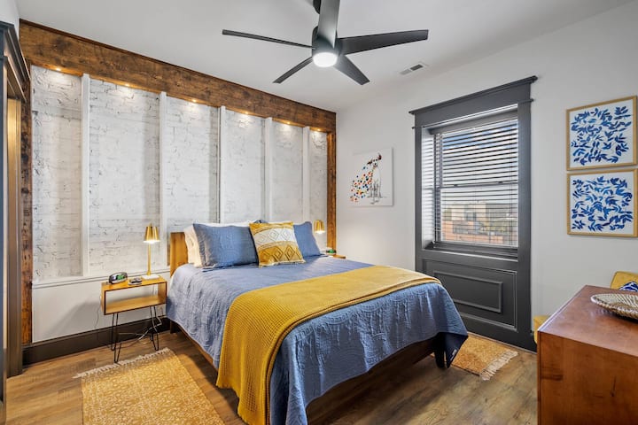 Primary bedroom with view of beam and original building brick.