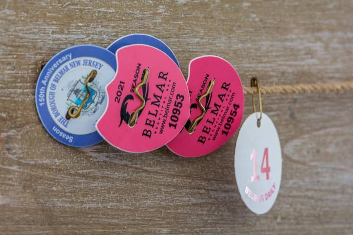 Nine Belmar seasonal beach badges laid out for the compound's guests