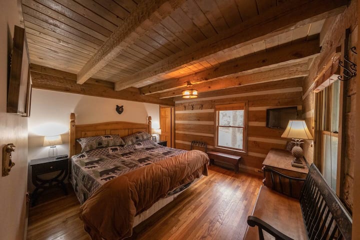 Main floor Bedroom with a King-sized bed, TV, and attached bathroom.
