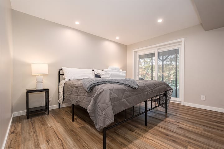 King Bedroom #4 iko kwenye usawa wa ziwa na ina nafasi kubwa.  Chumba hiki kina meza, ROKU SmartTV na milango inayoteleza inayoelekea kwenye sitaha ya chini karibu na beseni la maji moto.