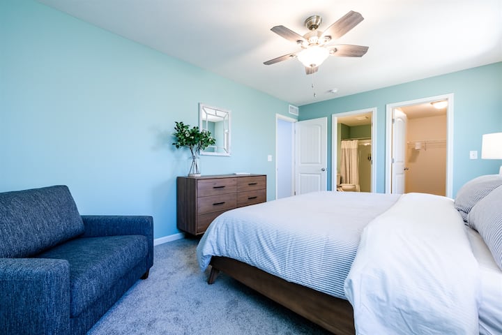 Chambre principale avec chaise qui s'ouvre sur un lit jumeau et une « petite pépinière » attenante