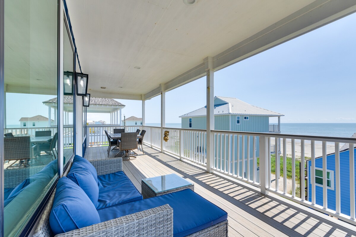A spacious balcony is adorned with comfortable lounge seating and a glass-top table, offering scenic views of the beach and ocean. The area features a light, airy atmosphere, enhanced by natural light reflecting off the nearby water.
