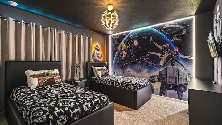 Žvaigždžių karų dvivietis kambarys su galaktiniu sienų menu, erdvės apšvietimu ir temine patalyne.