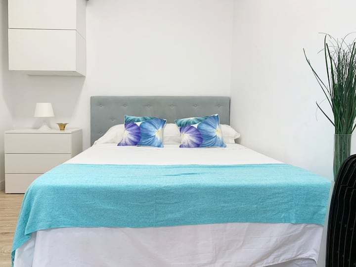 Dormitorio con una cómoda cama de tamaño completo y aire acondicionado