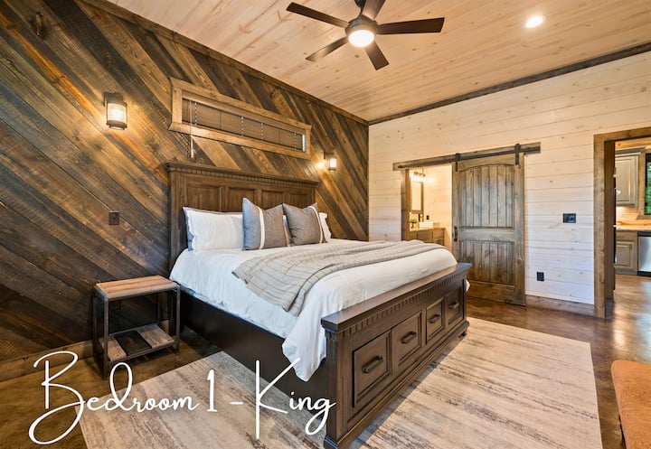 1 საძინებელში არის დიდი ზომის საწოლი შერეული ხის აქცენტის კედელთან, რომელიც სტილისა და კომფორტის ნაზავს გთავაზობთ.