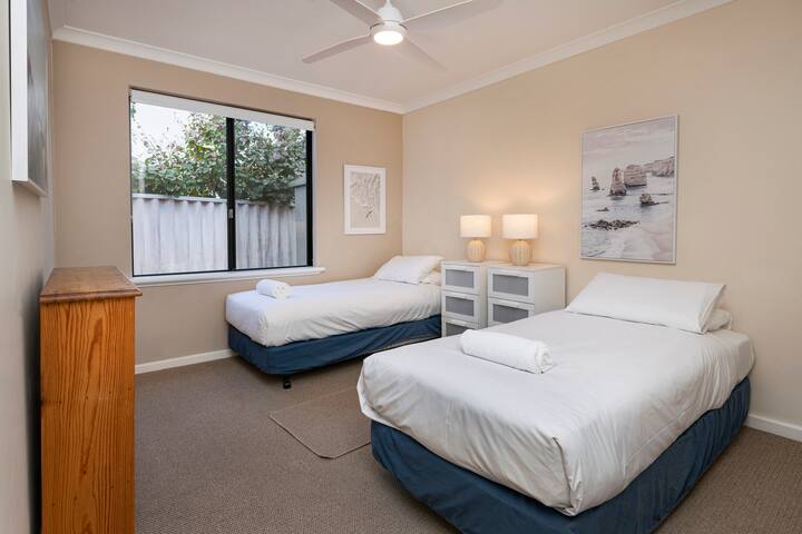 غرفة النوم المزدوجة المريحة، المكتملة بنوافذ كبيرة وإضاءة ناعمة، مثالية للسفر مع الأطفال.