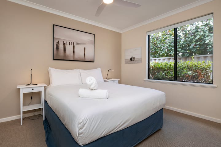 توفر غرفة النوم الثانية المريحة سريرًا متوسط الحجم مع إطلالة مورقة.