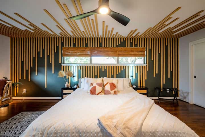 Striking designer bedroom with custom wood accent wall and plush king bed for a luxe night’s rest.