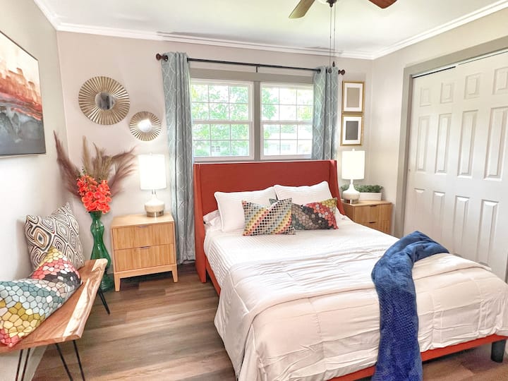 מיטת קווין סייז עם וילונות האפלה וגוונים רכים לשינה שלווה.