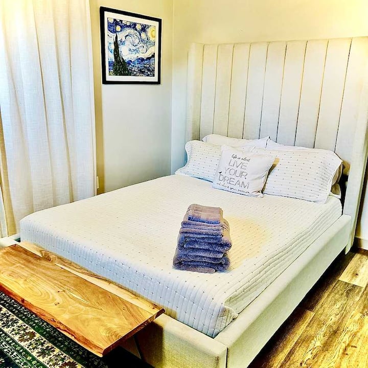 מיטת קווין סייז עם וילונות האפלה וגוונים רכים לשינה שלווה.