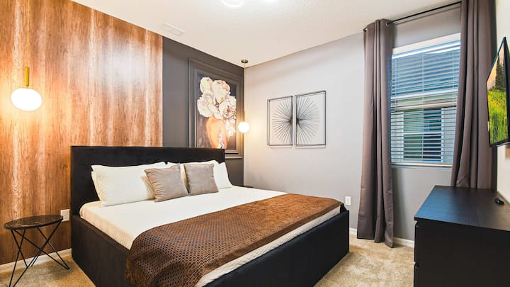 Acogedor dormitorio con elegante pared decorativa, decoración moderna e iluminación cálida.