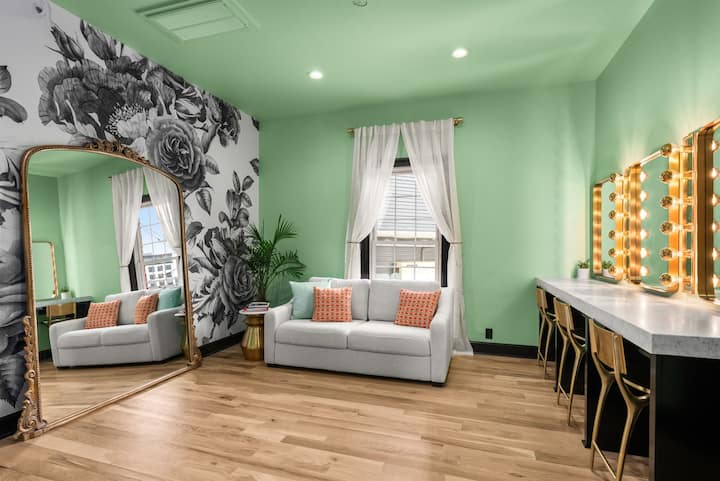 Check out the glamorous makeup vanity room adorned with stunning mural wallpaper, along with an extra comfortable queen size sleeper sofa.