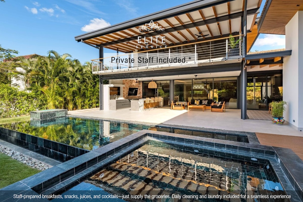 An outdoor space features a private pool and a heated jacuzzi, with tile surrounds. The home has large glass doors that open to a spacious living area highlighted by modern furnishings and greenery. A sense of openness is created by the architecture and natural light.