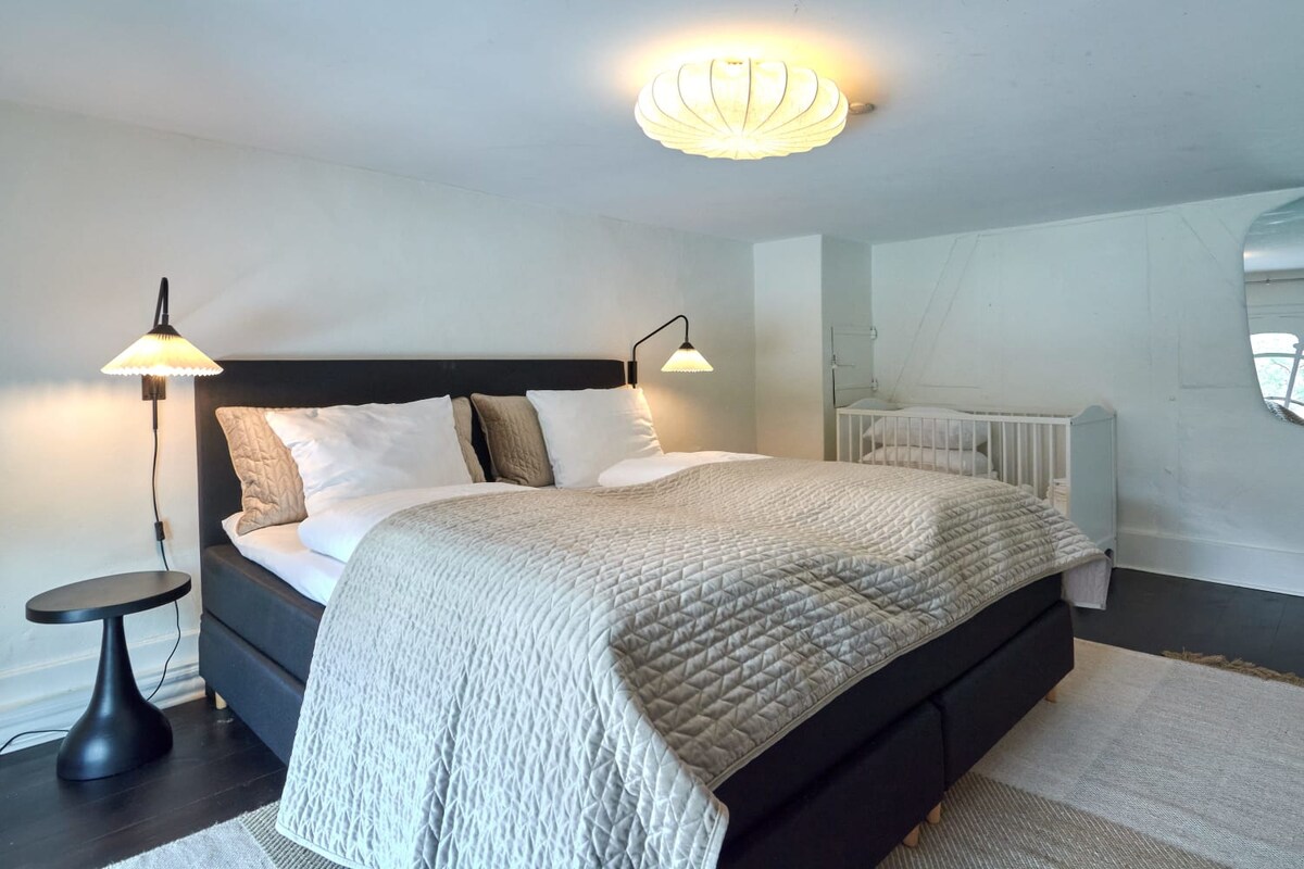 חדר שינה עם מיטת קינג סייז שנועדה להציע אווירה חמה ומזמינה.   הגוונים הנייטרליים מספקים תפאורה מרגיעה ומרגיעה לשינה ורוגע.