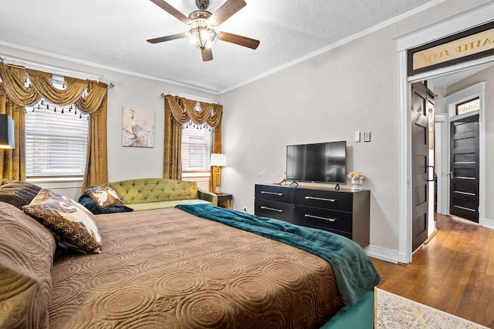 Slap af i et rummeligt soveværelse i nederste etage med en blød kingsize-dobbeltseng, elegante gardiner og en hyggelig sovesofa – perfekt til familier eller grupper, der bor i Midtown Kansas City.