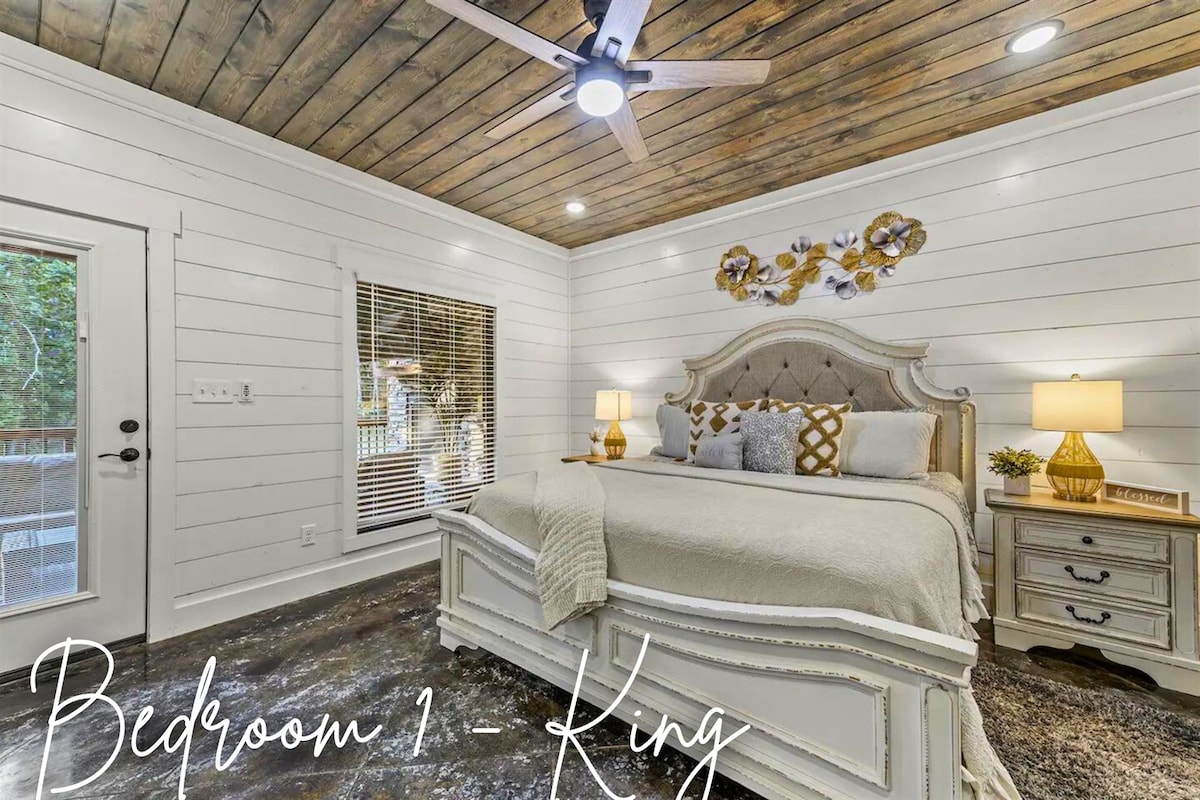 Relájate en este sereno dormitorio tamaño king con decoración elegante, ropa de cama lujosa y acceso directo al aire libre, ideal para tomar un café tranquilo por la mañana.