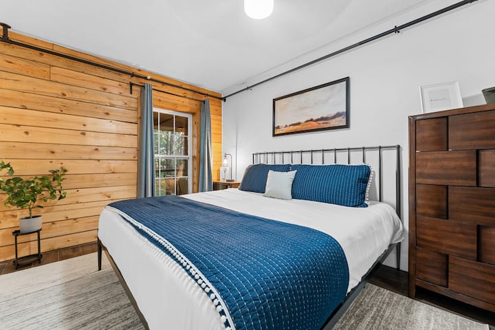 Este dormitorio principal de la cabaña tiene una cama tamaño king. Prepárate para relajarte con las lujosas sábanas y almohadas. Cada habitación tiene un televisor.