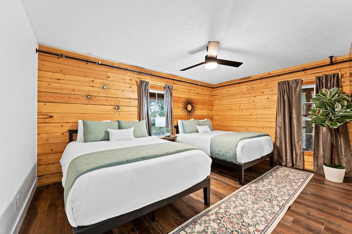 En el nivel principal de la cabaña, este dormitorio tiene 2 camas queen, un vestidor y un televisor. 