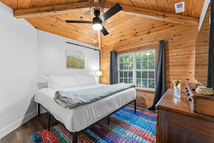 En el segundo nivel de la cabaña, este dormitorio tamaño king es perfecto para padres con un bebé o un niño pequeño. Esta habitación tiene un vestidor grande y abierto con una cuna de tamaño completo. Está conectado a una sala de juegos con una mecedora.