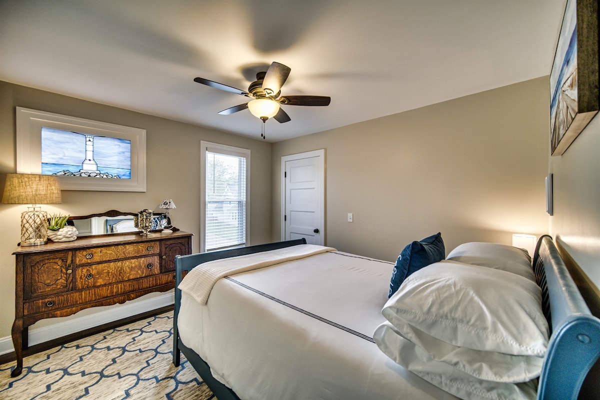 Lighthouse Room features a handmade, stained glass picture window of the Huron Lighthouse. Stunning shades of blue with serene beach artwork, our nod to Lake Erie. This room is guaranteed to make you feel relaxed and calm.