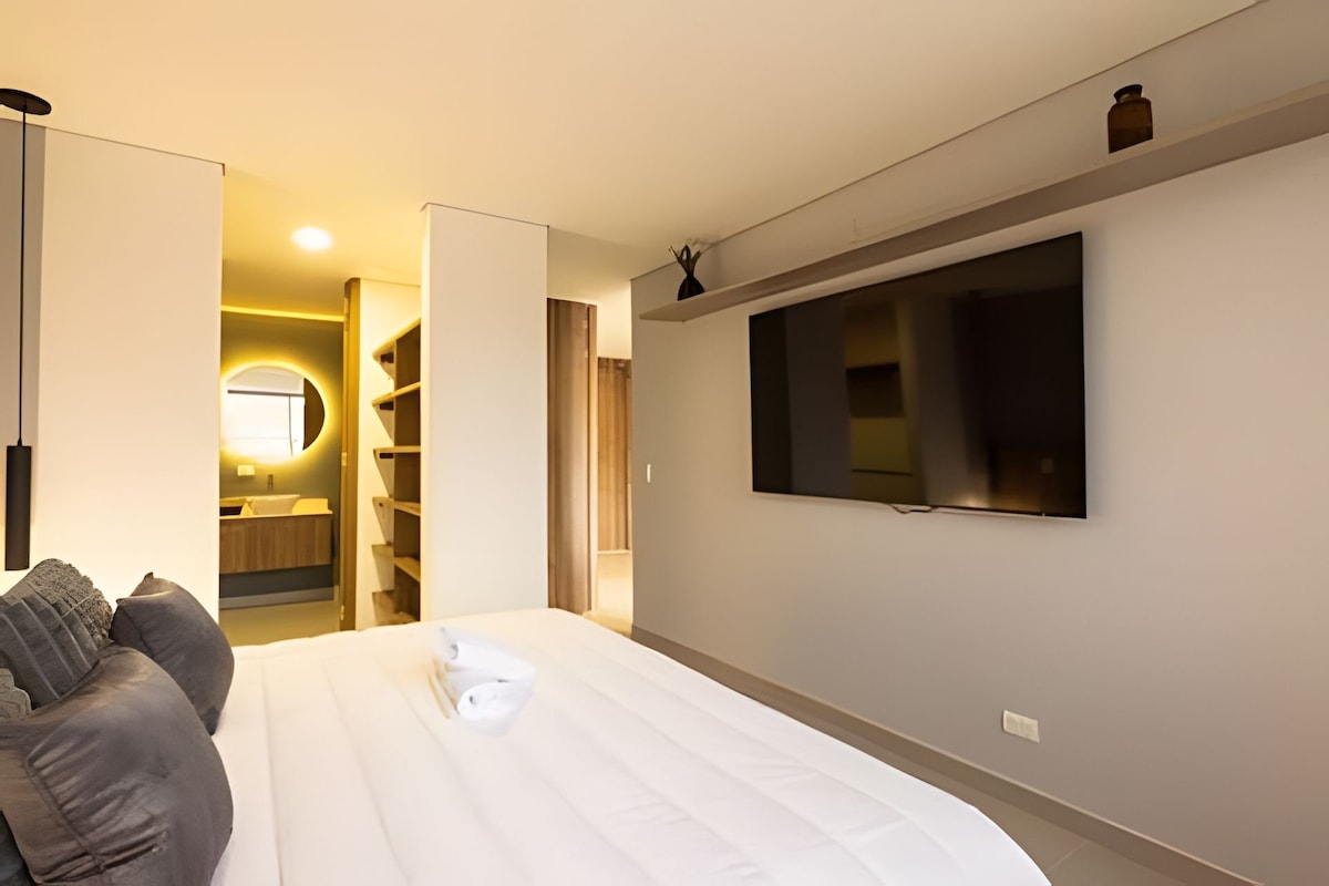 The master bedroom offers comfort and relaxation with an 85-inch Samsung TV, a spacious desk, air conditioning, blackout blinds, and elegant curtains. The luxurious king-sized bed with premium linens is ideal for unwinding after exploring.