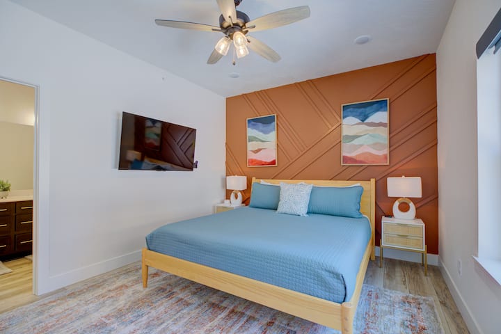 Dormitorio 2: suite King con pared personalizada, TV inteligente de55pulgadas y baño privado con tocador doble y ducha de puerta de vidrio con entorno de mármol cultivado.