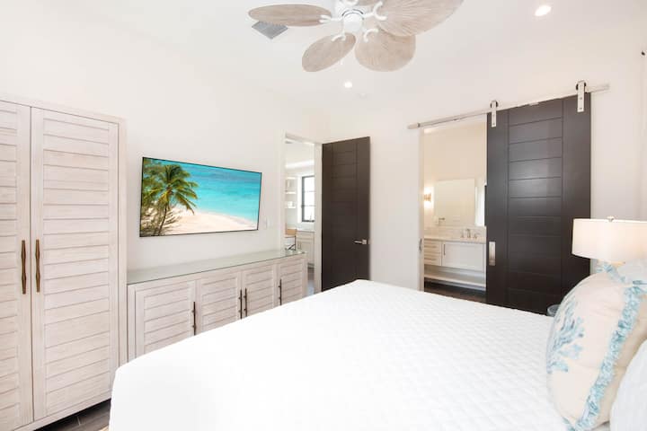 West Veranda Suite ? king bed, private entry, tall ceilings, walk-out access to pool and beachfront under the west veranda, television.
