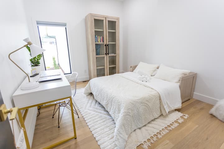 Fully equipped office with printer, desk, Murphy bed, and reading material.