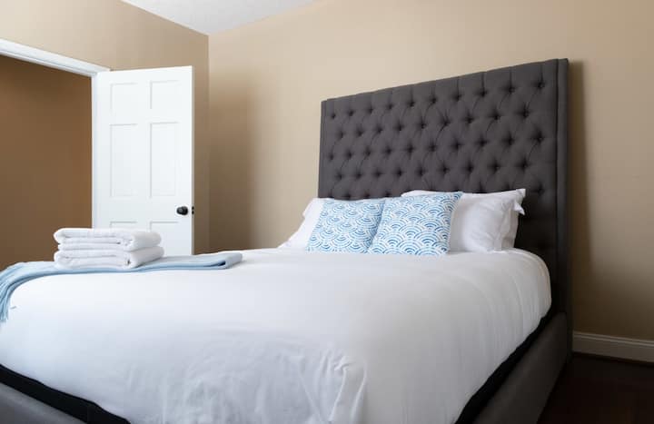 清潔で清潔なリネンと柔らかい寝具を備えた快適なクイーンサイズベッド