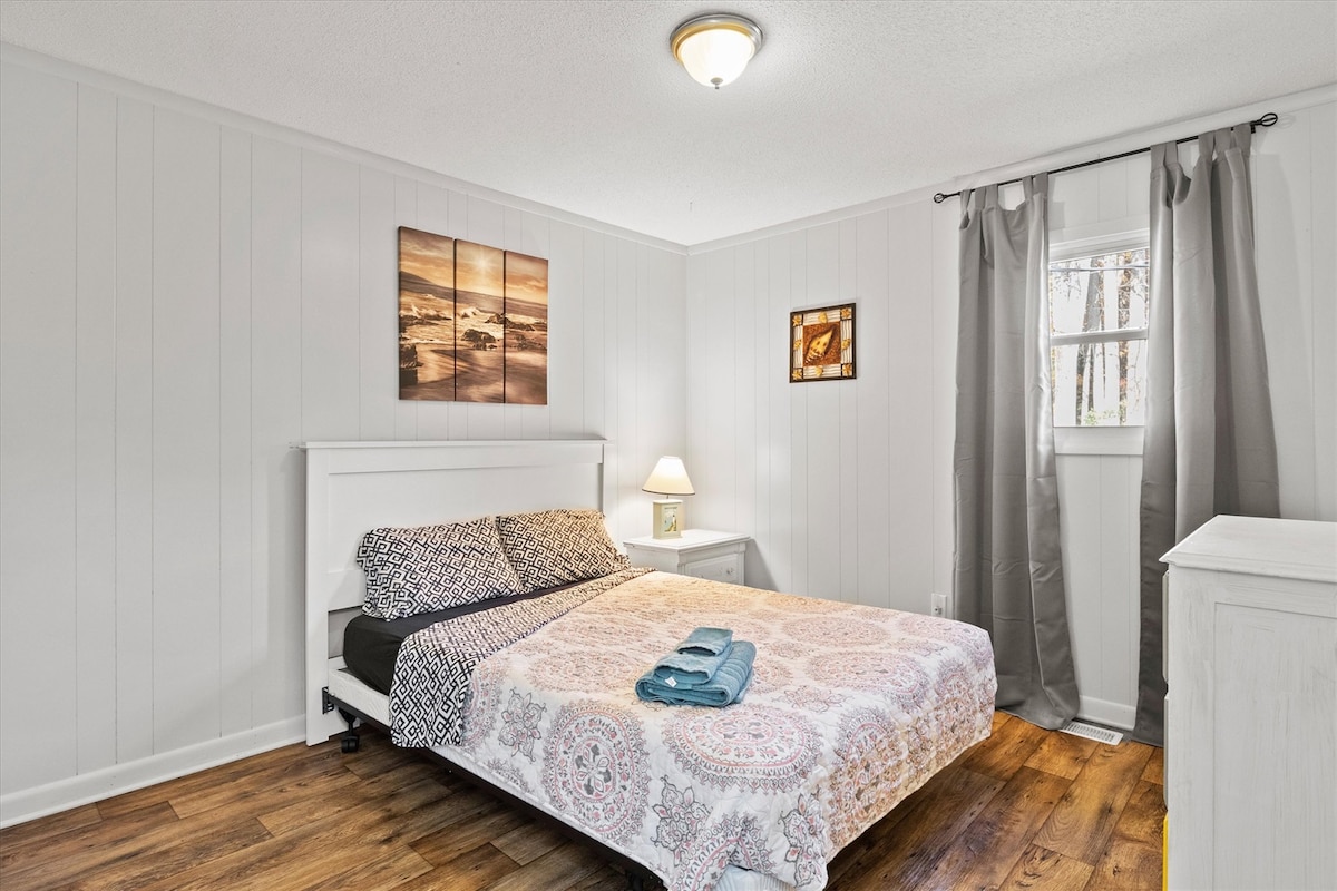 een ander groot comfortabel queensize bed wacht op je met een dressoir voor je spullen