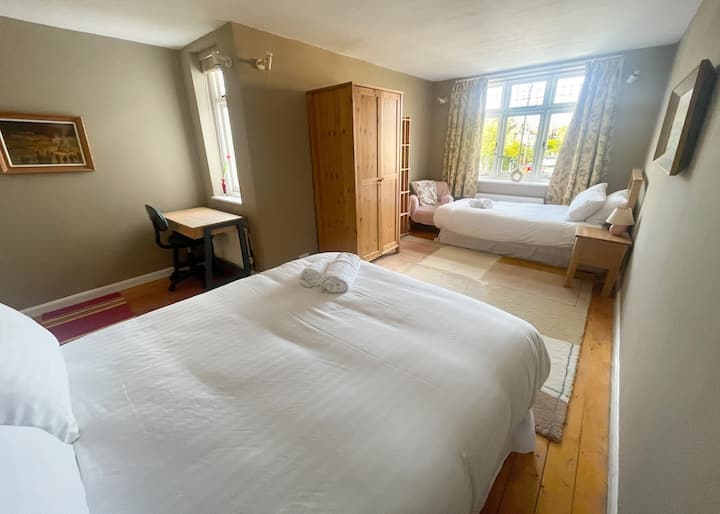 非常宽敞的卧室，配有加大双人床和单人床以及办公桌