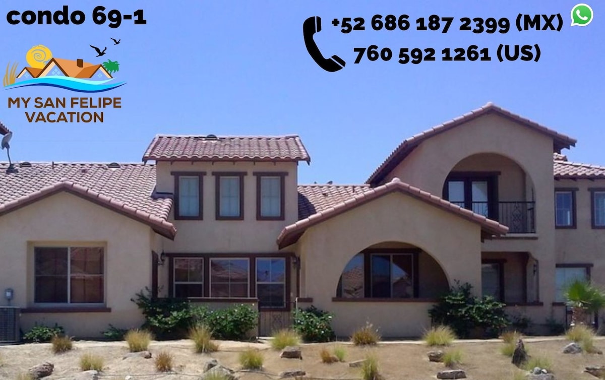 The exterior of the villa is showcased, featuring a two-story design with a stucco finish and tile roof. The entrance is framed by charming archways, and desert landscaping with native plants adds to the scenery. Contact information is displayed prominently for guests.