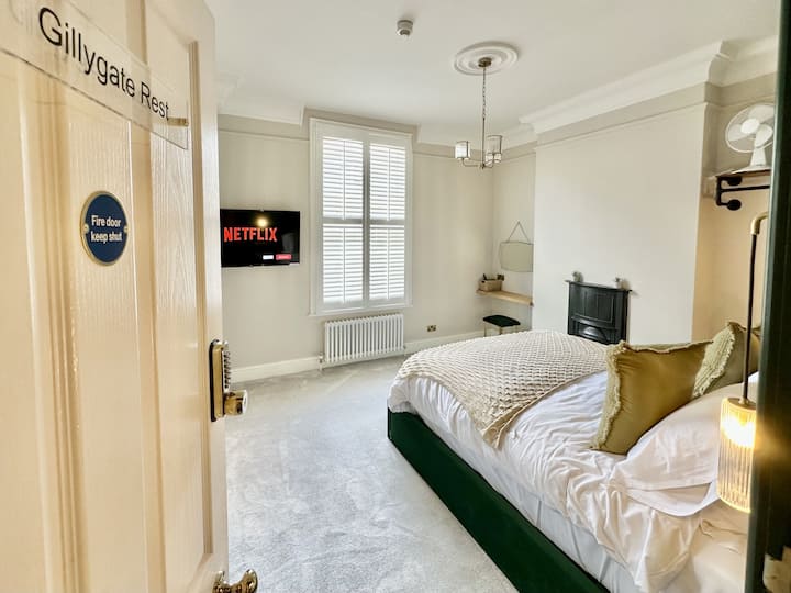Apartamenti ka një tavolinë zhveshjeje dhe parmak të varur 