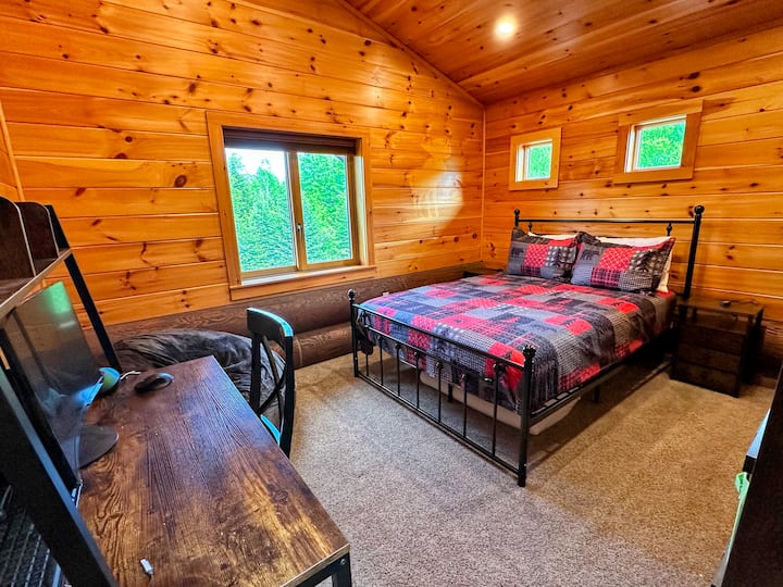Dormitorio en planta alta con cama tamaño queen y escritorio