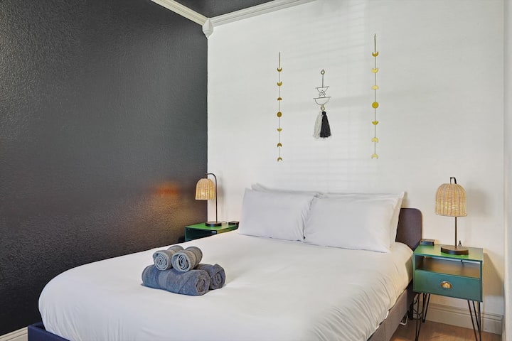 这间卧室装饰简约而优雅，装饰精美，配有装饰墙、配套的床头柜和舒适的毛绒床！