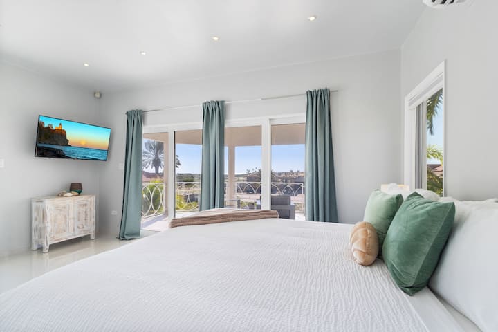 Панорамска спална соба на вилата во Норд Аруба - Удобен брачен кревет - Елегантно дизајнирана соба - Прекрасни обоени ѕидови со декорација - Величествени ламби за на маса - Убава и чиста постелнина - Големи прозорци со прекрасен поглед - достапен е телевизор и Netflix