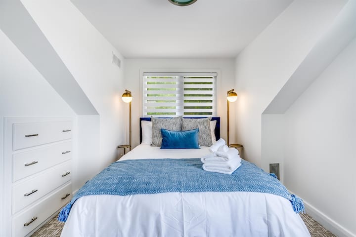Comfortable queen bedroom with calming tones.