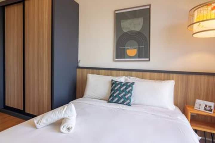 استرخ في غرفة نوم تتمتع بإطلالة خلابة على المدينة وسرير كينج كويل فاخر. يوفر الأثاث المعاصر والبياضات الفندقية مزيجًا مثاليًا من الراحة والرقي.