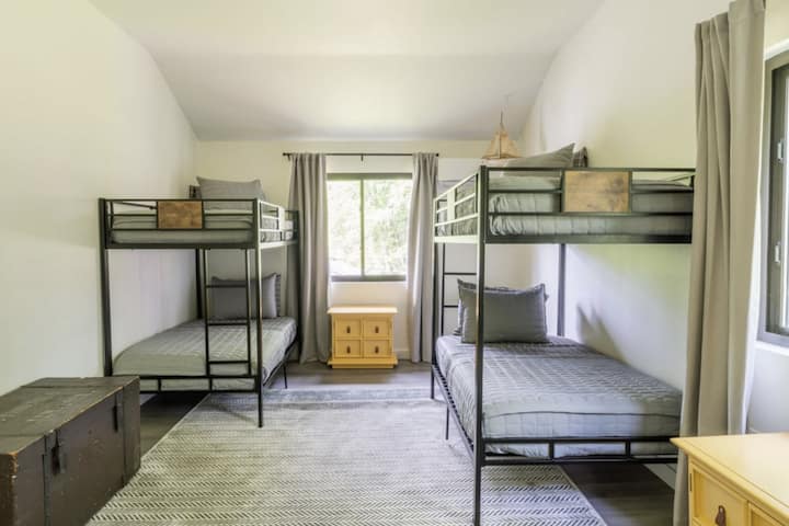 חדר שינה שלישי בקומה השנייה עם שני סטים של מיטות קומתיים זוגיות