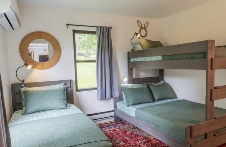 חדר שינה שני בקומה הראשית עם מיטה זוגית וסט אחד של מיטות קומותיים