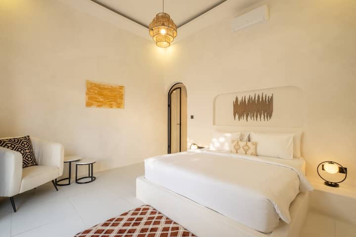 การตกแต่งภายในวิลล่าที่อบอุ่นและทันสมัยมีการออกแบบสีขาวสดใสและที่นั่งที่มีสไตล์