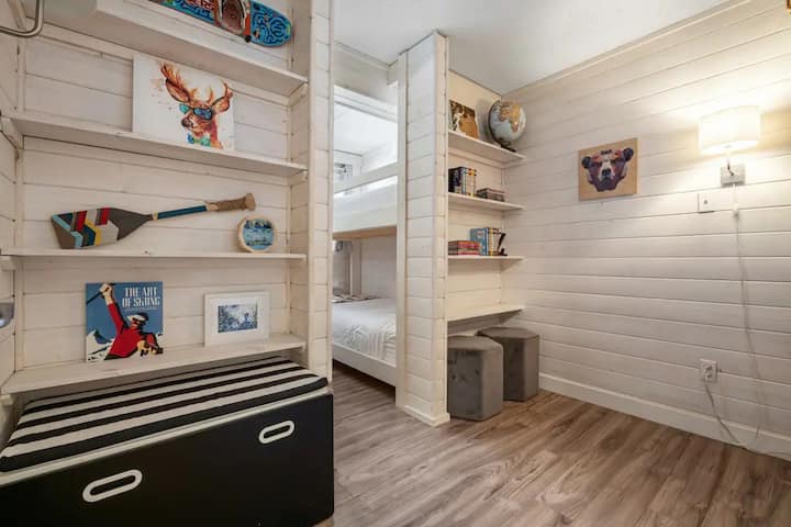 Ფოიე ორსართულიან ოთახში მინი სკამებით შეზლონგისა და ტელევიზორის საყურებლად
