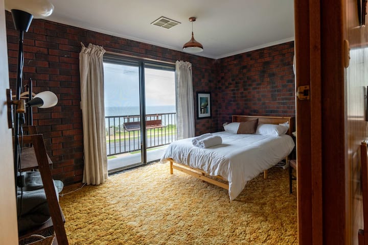 Dormitorio en la planta superior con cama doble y vistas al mar