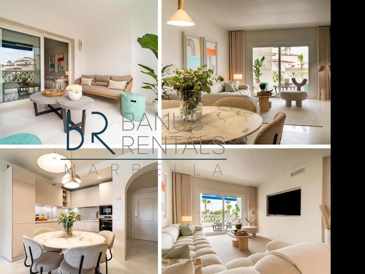 The open-plan living-dining area features a spacious layout, integrating a comfortable seating arrangement and a dining table. Large windows offer natural light and views of the terrace, while fresh greenery is placed strategically for a welcoming touch.