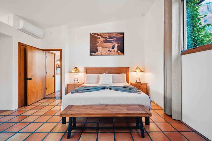 - Quarto com estrutura de cama de madeira e luminárias elegantes   - Decoração com detalhes terrosos que realçam a vibe do sudoeste   - Luz natural que enche o quarto com um brilho tranquilo